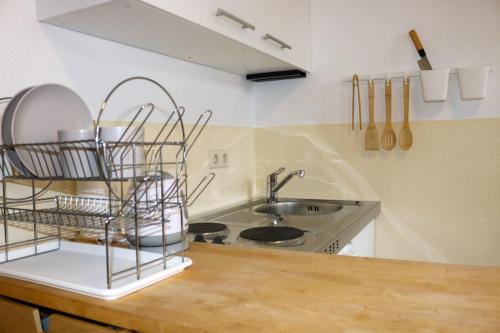 a kitchen counter with a sink and a plate rack at SchaeBu! Appartment 1 Die Ostsee am Altmarkt in Cottbus