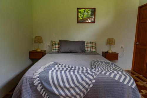 a bedroom with a bed with a blanket on it at Hotel Ecopaisajes- Lake-Premier-Resort in Quesada