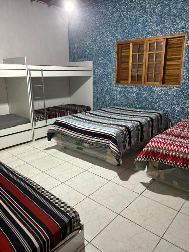two beds in a room with blue walls at Chácara Recanto dos Ipês - Igaratá in Igaratá