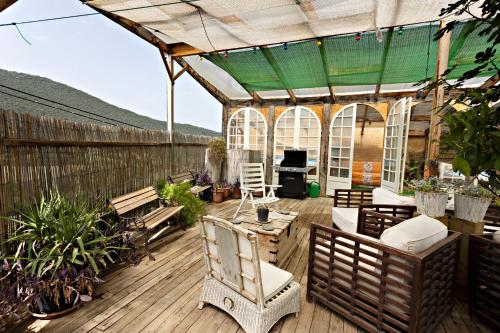 a patio with a wooden deck with benches and plants at Casa Rural Gite El Tossal in Collfred