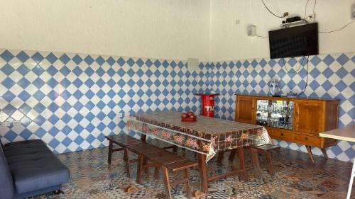 a dining room with a table and blue and white checkered wall at Chácara Recanto dos Ipês - Igaratá in Igaratá