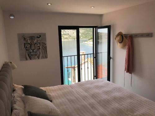 a bedroom with a bed and a picture of a tiger at Apartment White House in Vinišće