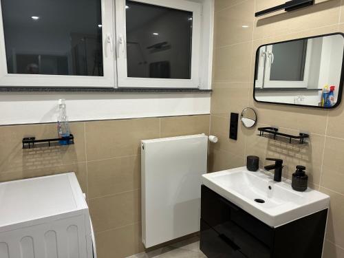a bathroom with a white sink and a mirror at FeWo Max in Freudenburg
