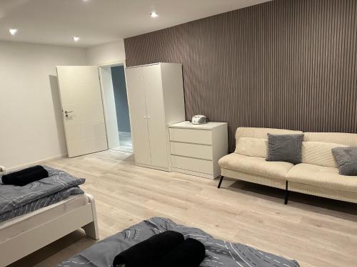 a bedroom with a bed and a couch and a mirror at FeWo Max in Freudenburg
