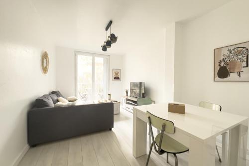 un salon blanc avec un canapé et une table dans l'établissement #HR Les Charmilles T4, à Grenoble