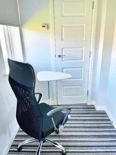 a black office chair sitting in front of a door at Newbuild - 3 bedrooms, 2 baths,5 mins from airport in Edinburgh