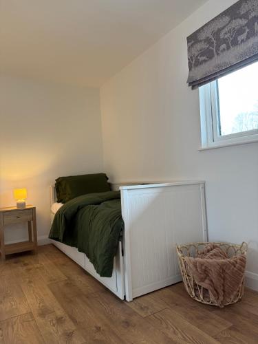 a white bedroom with a bed and a window at West Riverside Farm in Stirling