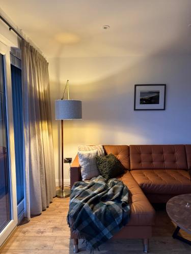 a living room with a brown couch and a table at West Riverside Farm in Stirling