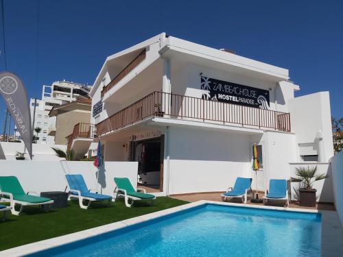 a villa with a swimming pool and chairs at Zambeachouse - Hostel Paradise in Areia Branca