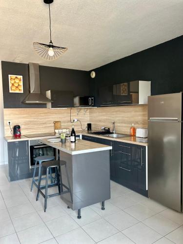 une cuisine avec un réfrigérateur et un plan de travail dans l'établissement LE JULA - APPARTEMENT T2 PROCHE CENTRE VILLE - Parking privé, à Albi