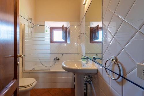 a bathroom with a sink and a shower and a toilet at Appartamento Mulino in Laterina