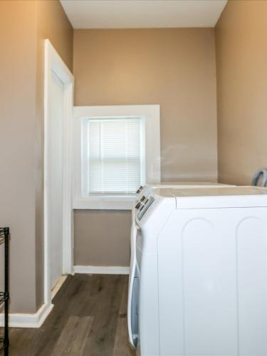 a laundry room with a refrigerator and a window at Sweet Stay in Memphis in Memphis