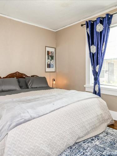 a bedroom with a large bed with blue curtains at Sweet Stay in Memphis in Memphis