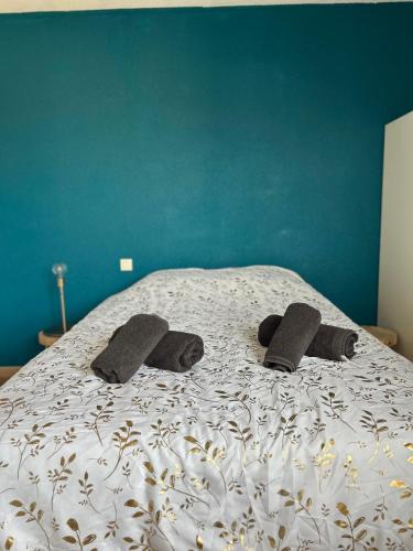 - un lit avec 2 paires de chaussons dans l'établissement LE JULA - APPARTEMENT T2 PROCHE CENTRE VILLE - Parking privé, à Albi