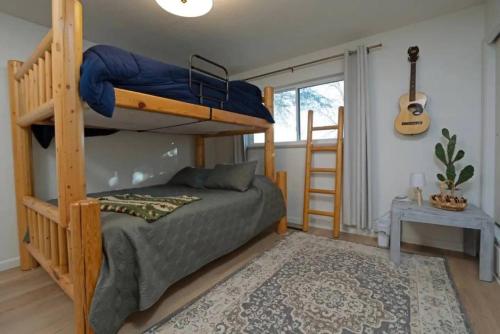 Un dormitorio con literas y una guitarra. en Nine Mile Ranch 4br, Views, Office, Fireplace, en Wellington