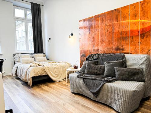 sypialnia z łóżkiem i kanapą obok krzesła w obiekcie 1min Walk to Market Square, Beautiful Views! Stylish 1BR Kitchen we Wrocławiu