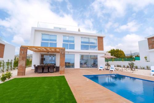 una villa con piscina y una casa en Coral Elite Residence Mit Pool Und Whirlpool, en Peyia