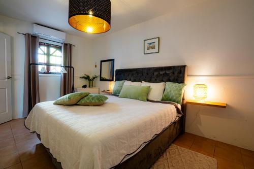 een slaapkamer met een groot bed met groene kussens erop bij Casa Leonore I in Willemstad