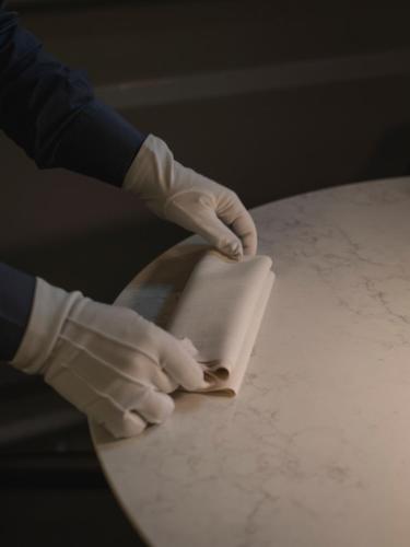 a person in white gloves cutting a piece of paper at I Portici Hotel Bologna in Bologna