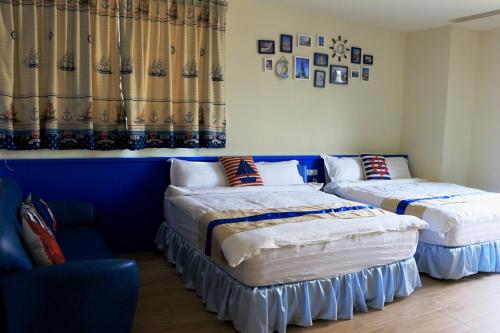 two beds in a room with blue walls and curtains at Waltz Villa in Puli