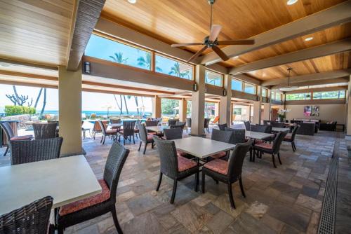 a restaurant with tables and chairs and a ceiling fan at Wailea Elua Resort 1904 in Wailea