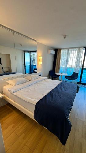 Orbi city mia luxury studio في باتومي: غرفة نوم بسرير كبير ومرآة كبيرة