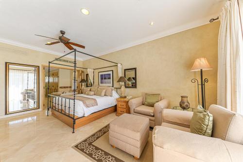 a bedroom with a bed and a living room at Villa La Estancia in Cabo San Lucas