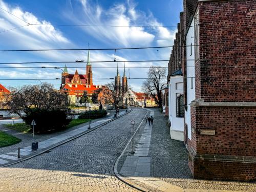 a cobblestone street in a town with a castle at Luxury Decor & Amazing Island Views, Center! 5mins Rynek in Wrocław