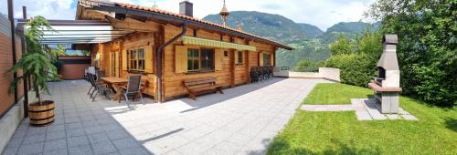 ein Holzhaus mit einem Tisch und einer Terrasse in der Unterkunft Ferienhaus in Sautens mit Garten, Pool und Grill und Panoramablick in Sautens