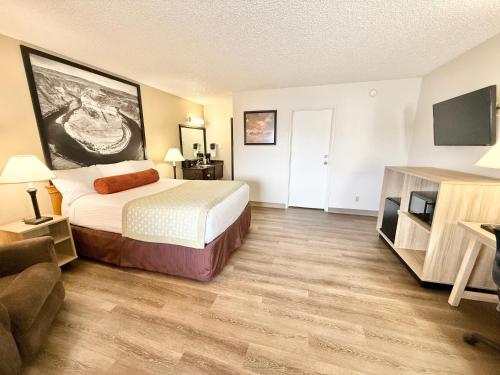 a hotel room with a bed and a flat screen tv at Super 8 by Wyndham Salina/Scenic Hills Area in Salina