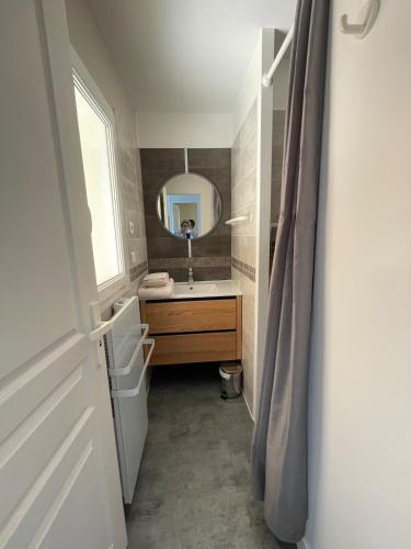 une salle de bain avec un lavabo et un miroir dans l'établissement Cap Morgat à l'écho des vagues, à Crozon