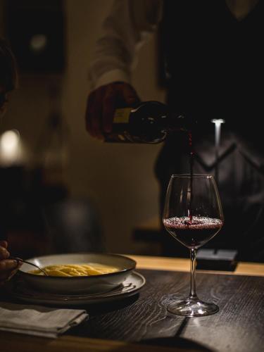 a person pouring wine into a glass on a table at I Portici Hotel Bologna in Bologna