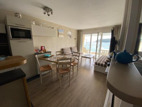 Una cocina y una sala de estar con mesa y sillas. en Cap Morgat à l'écho des vagues, en Crozon