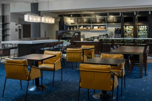 a restaurant with tables and chairs and a bar at Courtyard by Marriott Jackson Airport/Pearl in Pearl