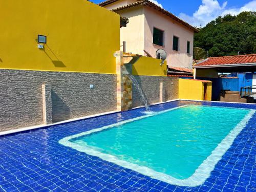 a swimming pool on the side of a house at Casa de temporada Bem-Te-Vi in Porto Seguro