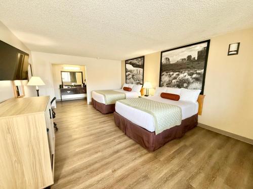 a hotel room with two beds and paintings on the walls at Super 8 by Wyndham Salina/Scenic Hills Area in Salina