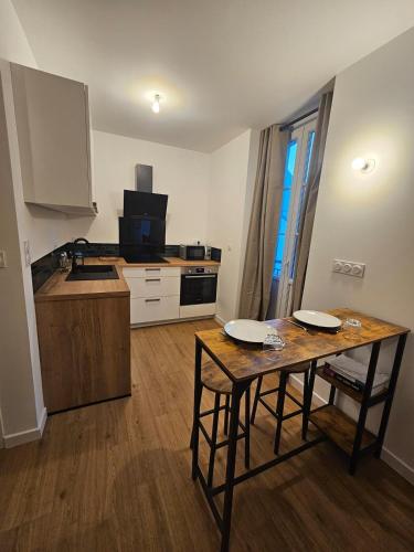 une cuisine avec une table et des chaises dans une pièce dans l'établissement L'Authentique - Studio 3, à Loudéac