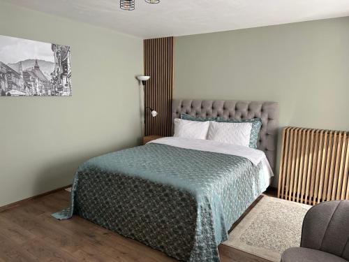 a bedroom with a bed and a chair in it at VYO Studio in Braşov