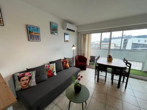 un salon avec un canapé et une table dans l'établissement Appartement T2 avec loggias, face aux thermes, parking privé, WIFI gratuit, animaux admis - Balaruc - FR-1-503-138, à Balaruc-les-Bains