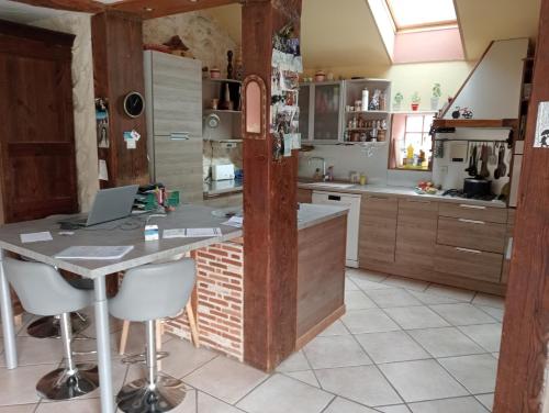 a kitchen with a table with a laptop on it at chambre d'hôtes au cœur de la nature in Saint-Roch