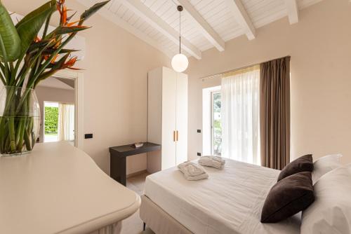 カンポフェリーチェ・ディ・ロッチェッラにあるVilla Dafni Private Pool & Relax near Cefalùの白いベッドルーム(大型ベッド1台、花瓶1本付)