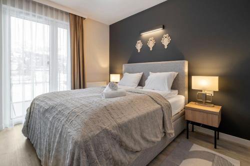 a bedroom with a large bed with a large window at 408 - Apartament Zakopiański z balkonem - Sauna & Jacuzzi & Plac zabaw & Siłownia in Zakopane