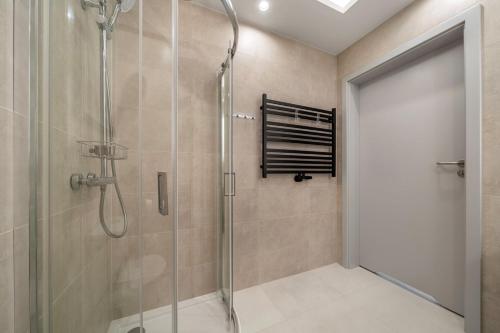 a shower with a glass shower door in a bathroom at 408 - Apartament Zakopiański z balkonem - Sauna & Jacuzzi & Plac zabaw & Siłownia in Zakopane