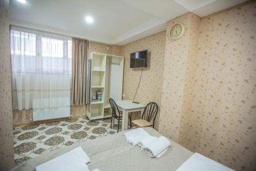 トビリシにあるTbilisi Townのベッドが2つと机とテーブルがある部屋