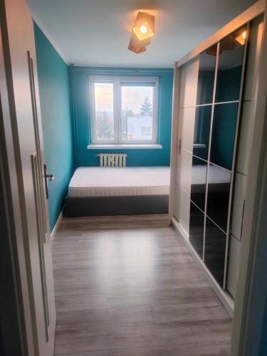 a small room with a bed and a window at Piąteczka in Pniewy