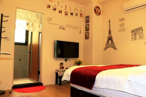 a bedroom with a bed and a television and the eiffel tower at Waltz Villa in Puli