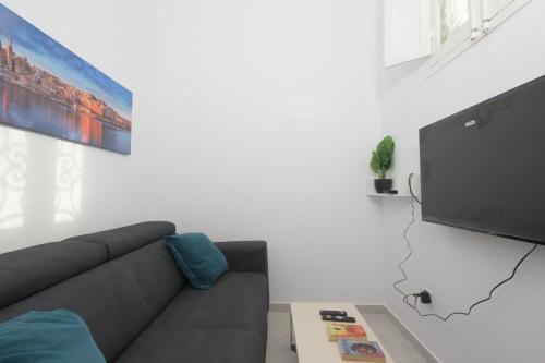a living room with a couch and a flat screen tv at Stylish Valletta 1 bedooom Penthouse with Terrace in the centre with Views in Valletta