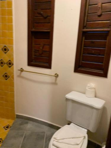 a bathroom with a white toilet and a window at Mantaray Tulum in Tulum