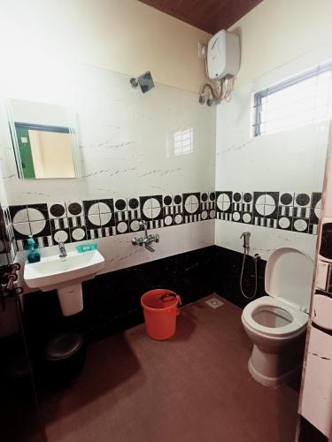 a bathroom with a toilet and a sink at Maanyatha Homestay in Udupi
