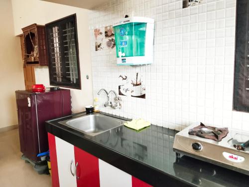 a kitchen with a sink and a counter top at Maanyatha Homestay in Udupi